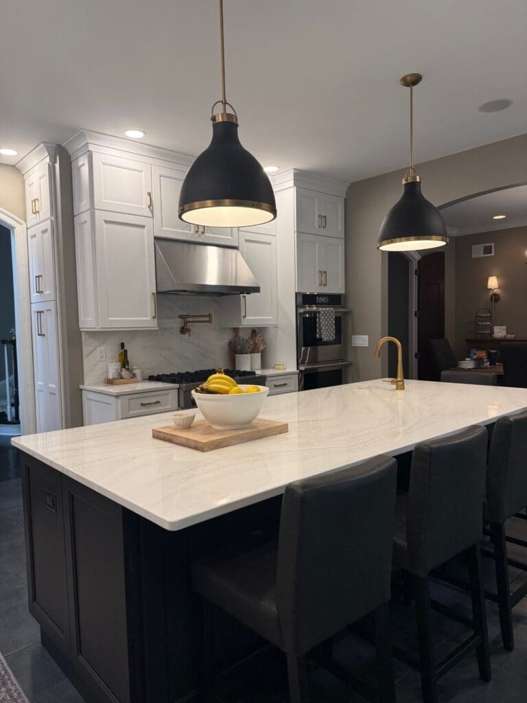 A kitchen island with lights hanging above.